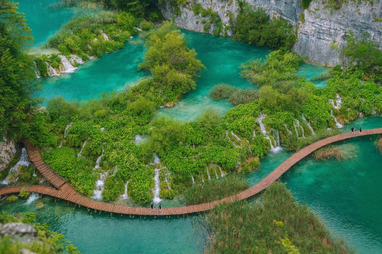 Pemandangan Plitvice Lake yang menakjubkan dalam pakej Balkan Budapest 4 negara dengan tasik biru jernih dan laluan kayu.