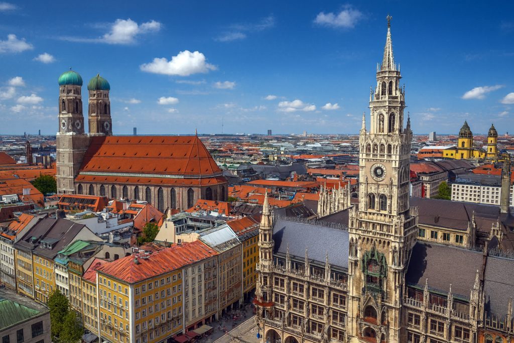 Pakej Eropah Timur - Marienplatz Munich dengan Neues Rathaus dan Frauenkirche berlatarbelakangkan pemandangan bandar Bavaria