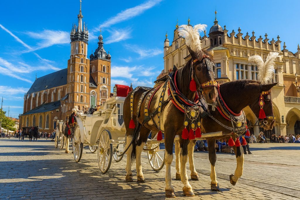 Pakej Eropah Timur - kereta kuda tradisional di Rynek Glowny Krakow dengan latar St. Mary’s Basilica dan Cloth Hall